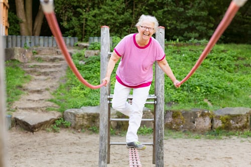 cheerful--senior-woman-on-playground-balancing-589428610_5760x3840